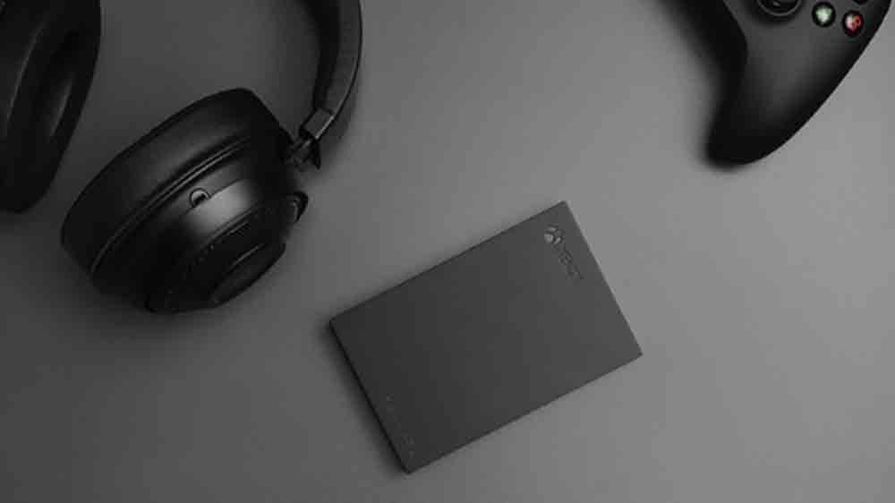 Externí disk Seagate Game Drive for Xbox vedle sluchátek a batohu_03