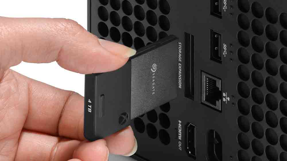 Člověk zasouvá kartu Seagate seagate Expansion Card do konzole_02