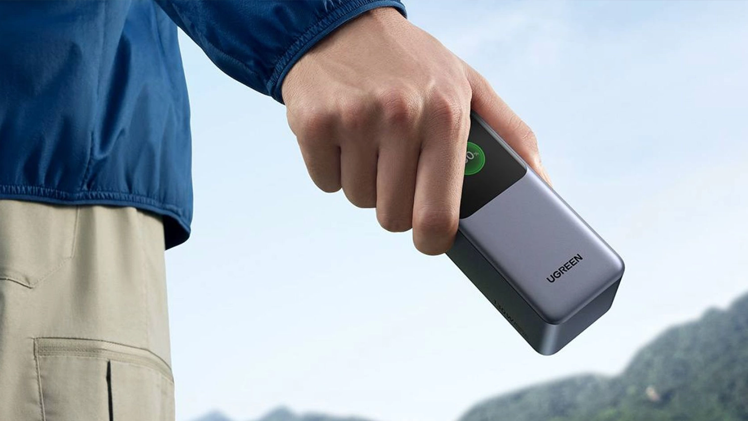 Muž drž&iacute;c&iacute; powebanku Ugreen Quick Charging 130W