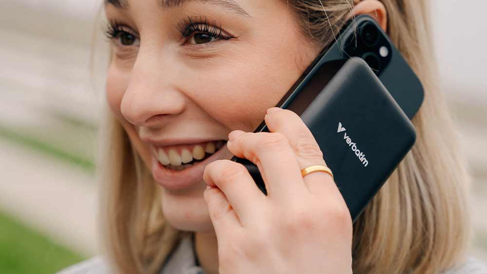 Mladá žena telefonuje a na telefonu má připojenou powerbanku Verbatim Charge 'n' Go Essentials_02