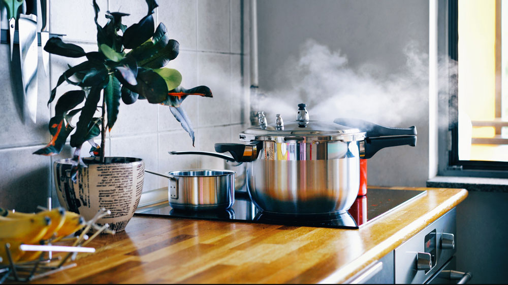 Muž varí rezance v hrnci na sporáku_02