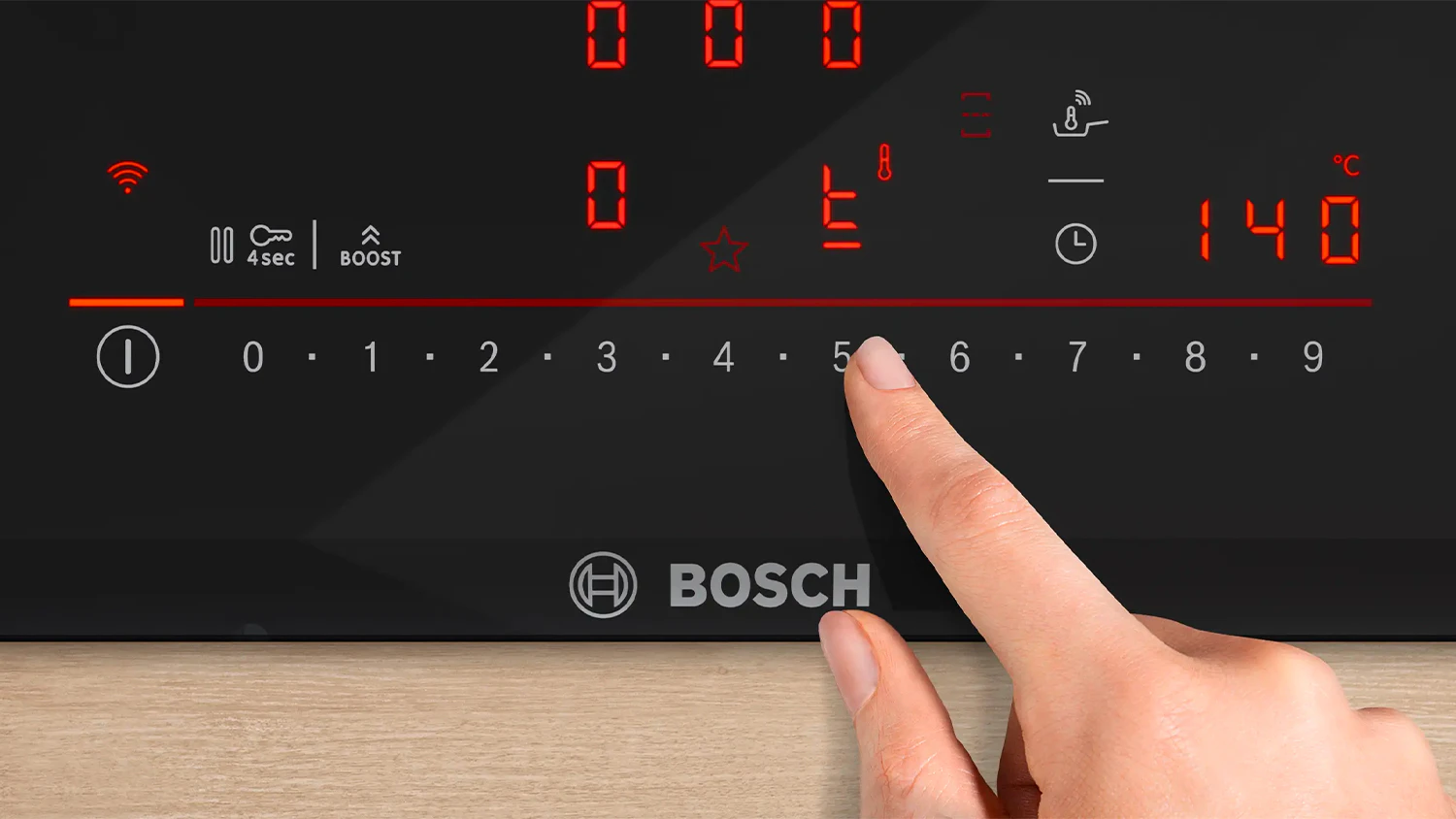Ruka dot&yacute;kaj&iacute;c&iacute; se ovl&aacute;dac&iacute;ho panelu na varn&eacute; desce Bosch