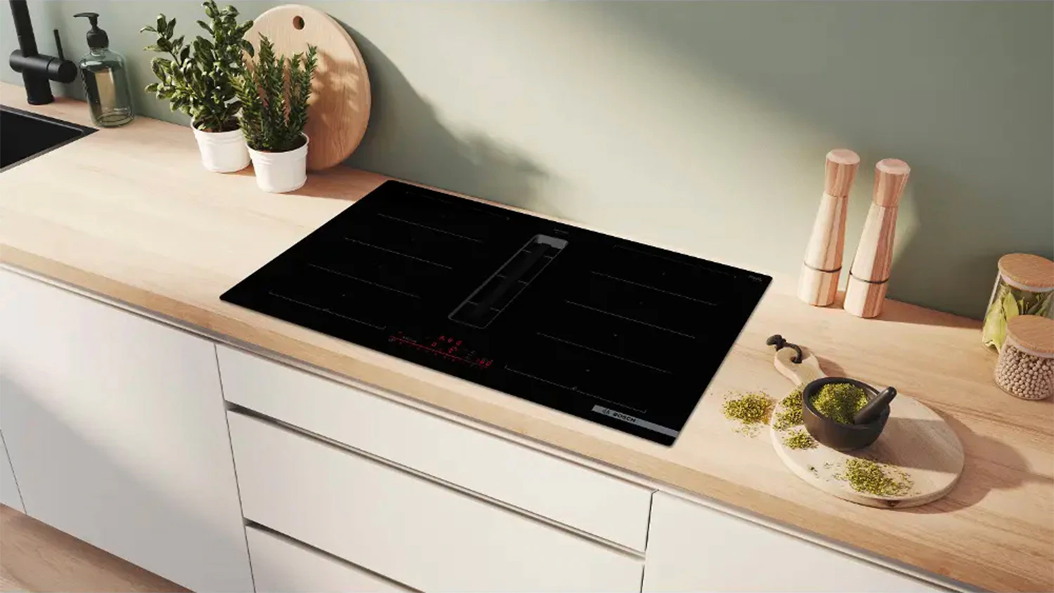Indukčn&iacute; varn&aacute; deska Bosch PXL811H26E zabudovan&aacute; v kuchyňsk&eacute; lince a bylinky