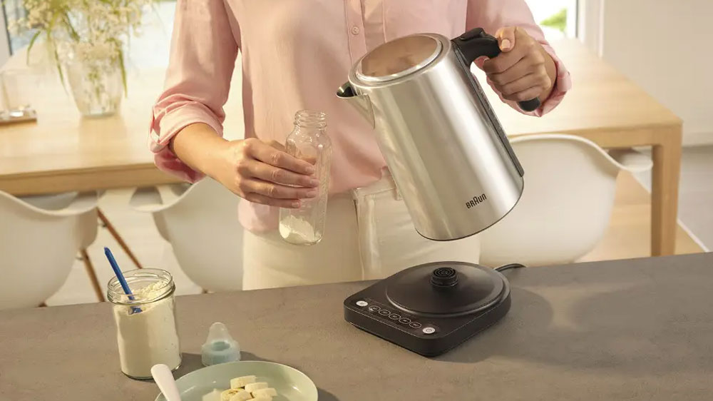 Žena nalévající vodu z konvice Braun WK5205BK do lahve_03