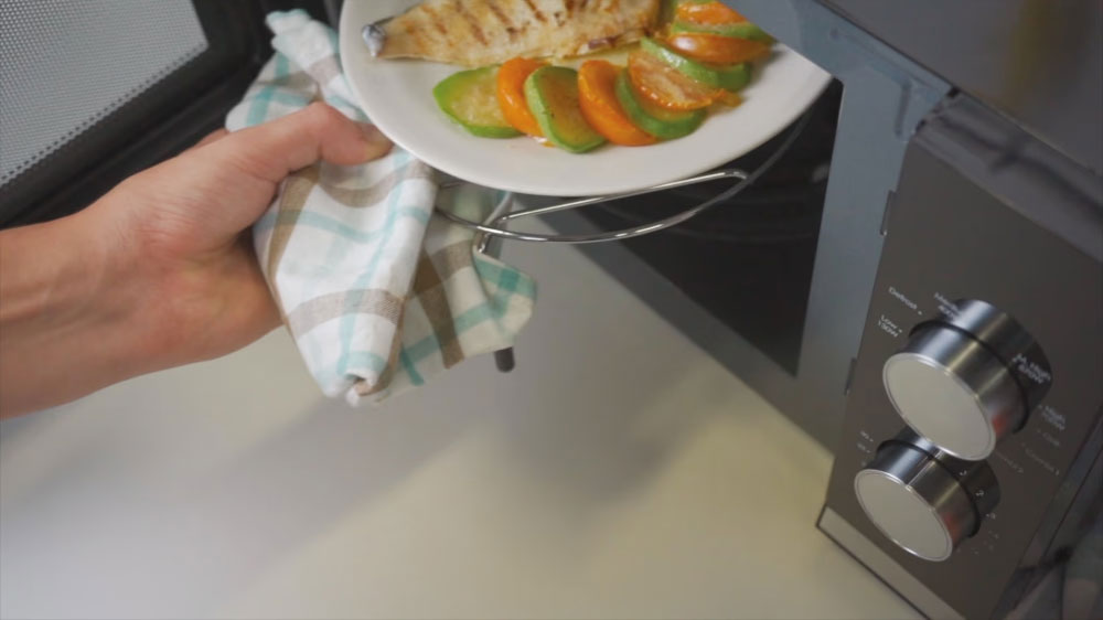 Žena vytahuje jídlo z mikrovlnky Candy_04