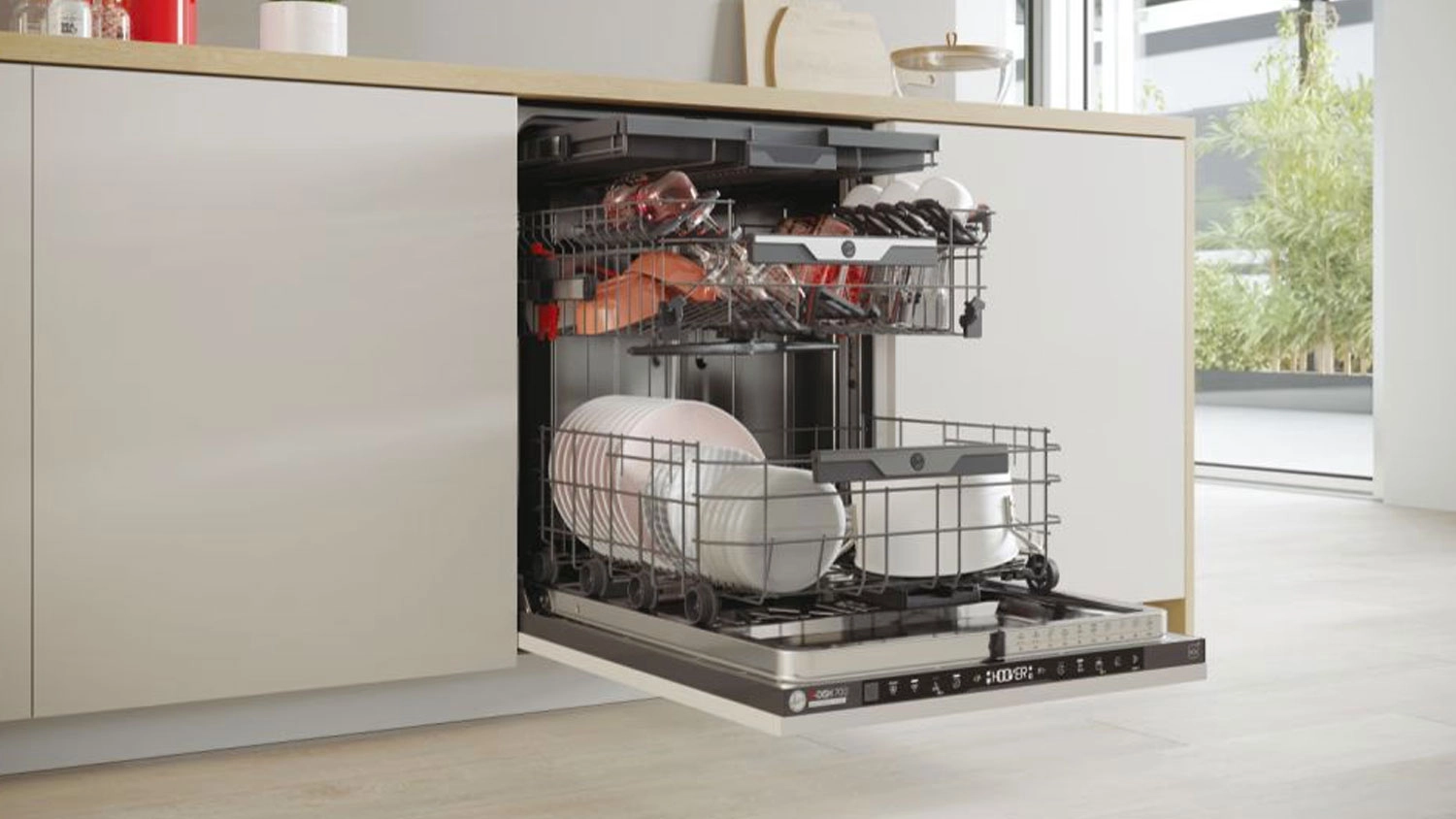 Vestavná myčka Hoover H-DISH 700HI 6B4S1PTA v kuchyni naplněná nádobím.
