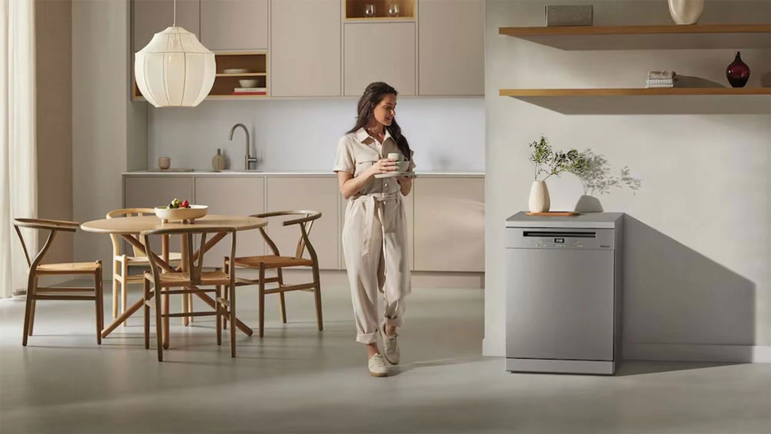 Žena proch&aacute;zej&iacute;c&iacute; kolem myčky Miele G 5811 SC Active Plus