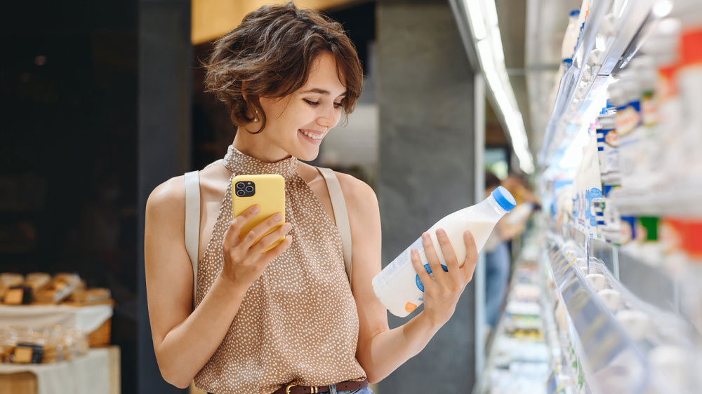 Žena s mobilom vyberá potraviny v supermarkete_05