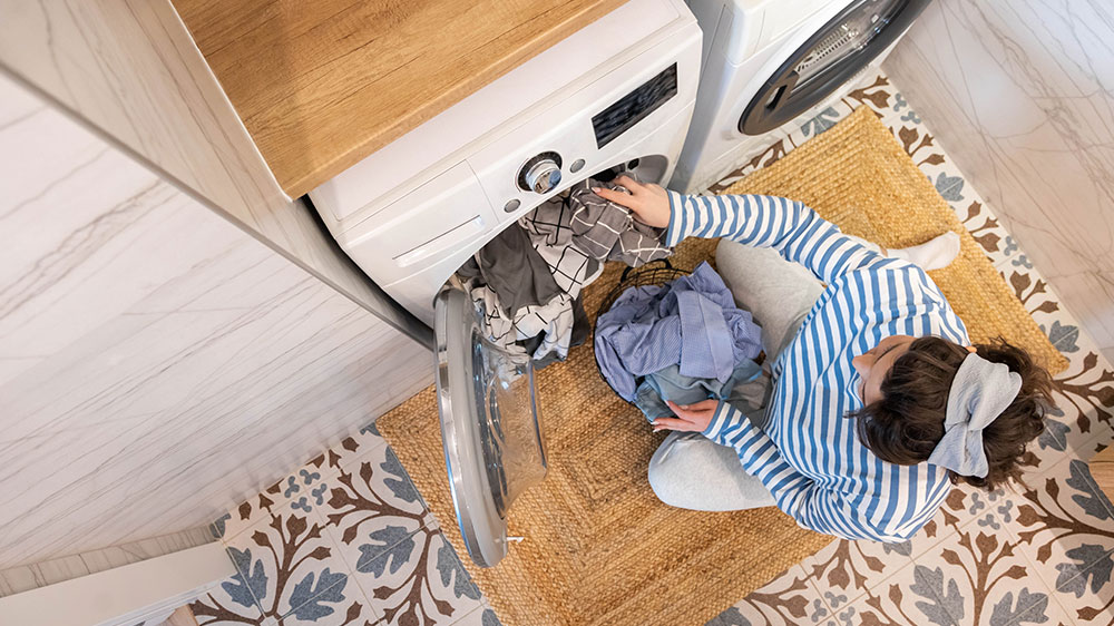 Žena vkládá oblečení do pračky _02