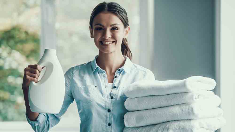 Žena drž&iacute;c&iacute; prac&iacute; prostředek a hrom&aacute;dku čist&eacute;ho pr&aacute;dla_03