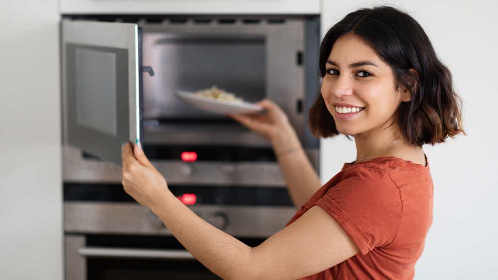Žena dává jídlo do mikrovlnky_03