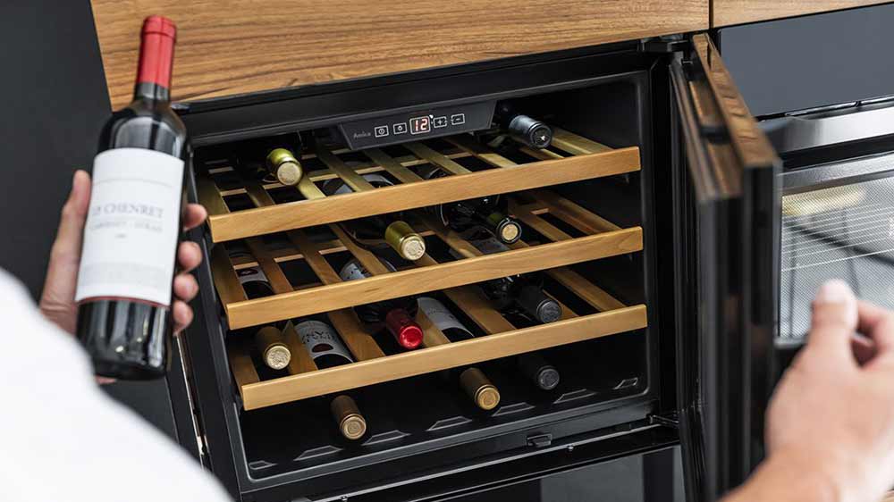 Muž vytahuje víno z vinotéky Amica WBA 2455 DB _02