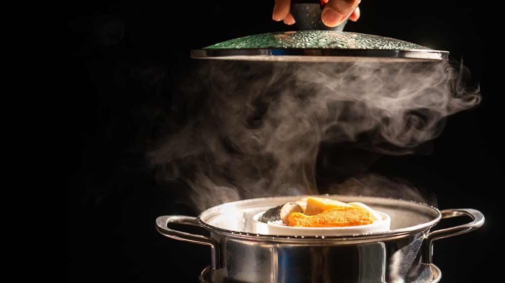 Ruka zvedající pokličku hrnce, ve kterém se vaří jídlo_02