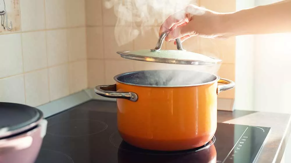 Ruka drž&iacute;c&iacute; pokličku u kouř&iacute;c&iacute;ho hrnce_02