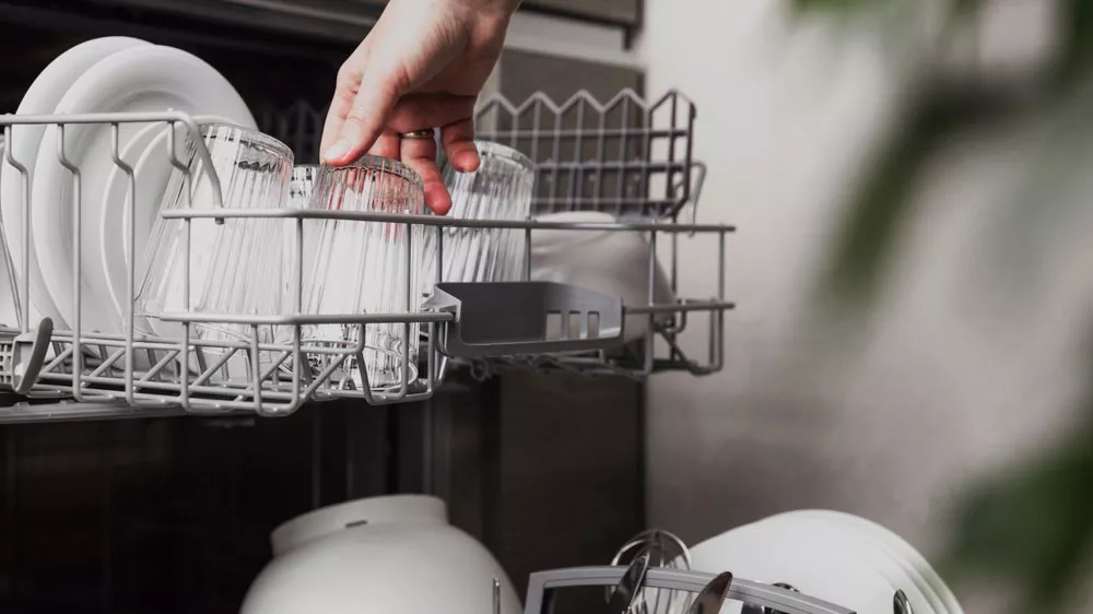 Žena vynd&aacute;v&aacute; skleničku z horn&iacute;ho ko&scaron;e myčky Beko DIS35023_02