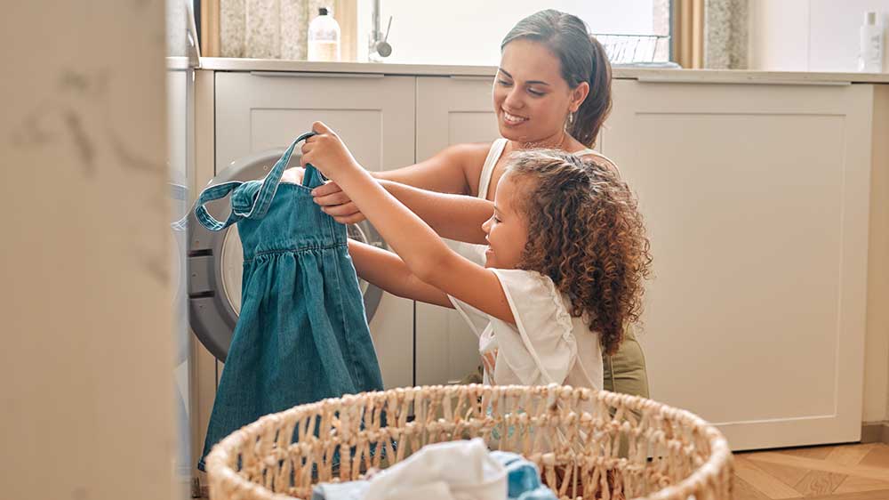 Matka s dcerou vytahují prádlo z pračky_05