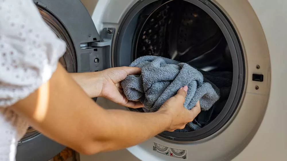 Žena vkl&aacute;d&aacute; pr&aacute;dlo do pračky_02
