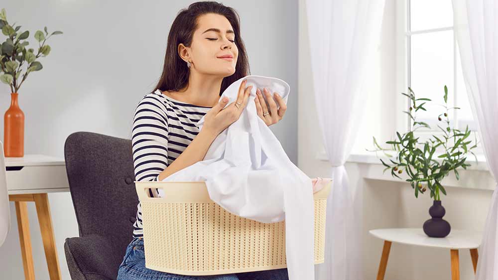 Žena čichá k vypranému a svěžímu oblečení_04