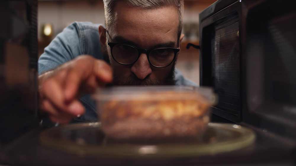 Muž vyndává jídlo z mikrovlnné trouby_07