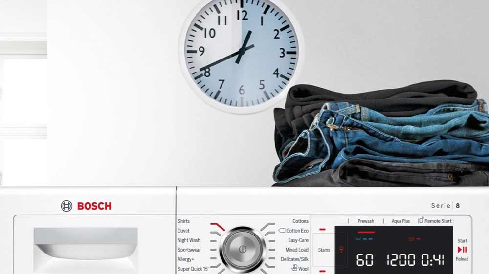 Horní panel s LED displejem pračky Bosch WAN21684BY a na ní kupička poskládaných džín_06