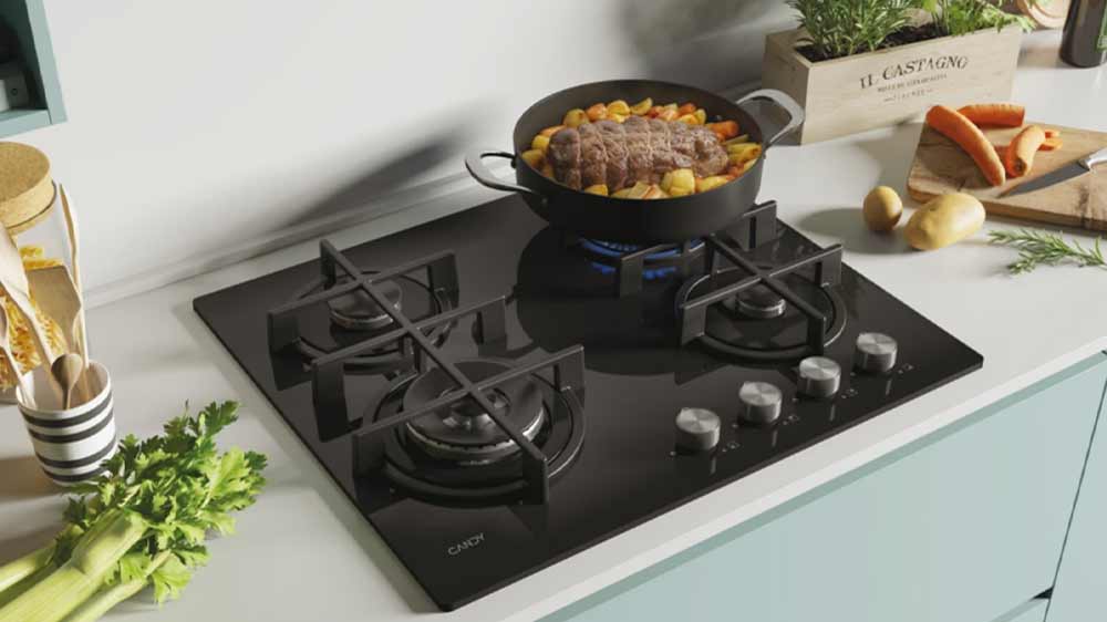 Na plynové varné desce Candy CDK6GF4WEKB Timeless se v hluboké pánvi připravuje jídlo_03