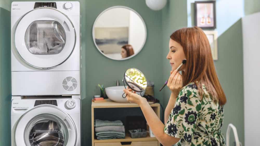 Sušení prádla v sušičce CANDY RO4H7A2TCEX-S, vedle ní se žena líčí_03