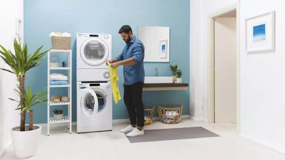 Muž vyndává prádlo se sušičky Candy Smart Pro CSOE H10A2TE-S_04