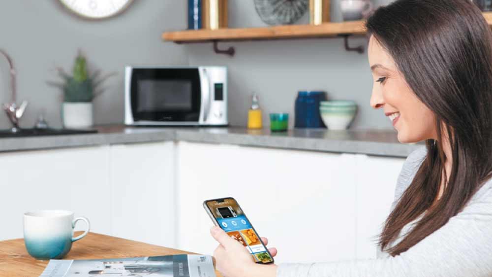 Žena sleduje na telefonu aplikaci hOn_03