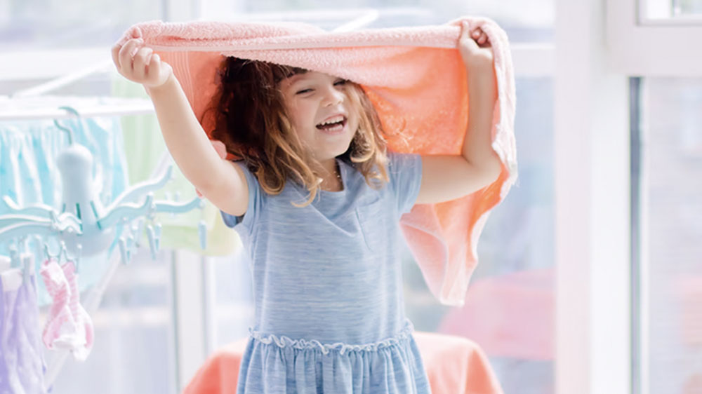 Holčička si hraje s vypraným ručníkem_03