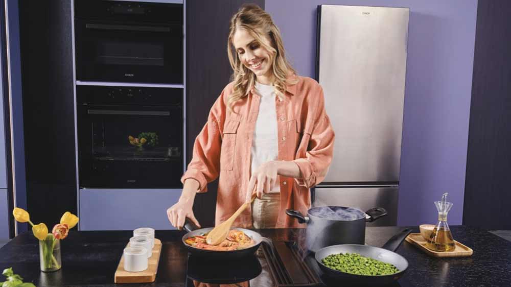 Žena vaří na indukční varné desce Candy Cook CIH6I4CE_02