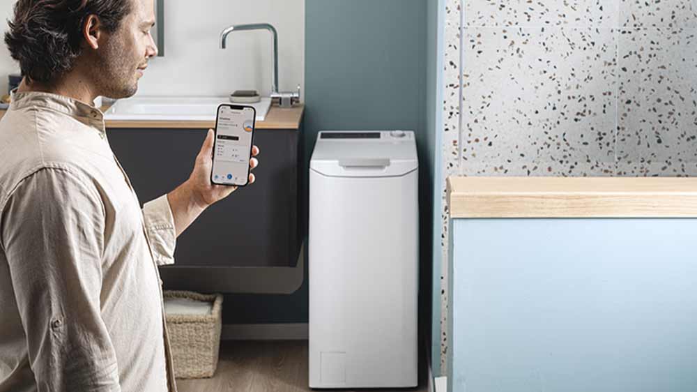 Muž ovládá pračku Candy pomocí aplikace ve svém smartphonu_05