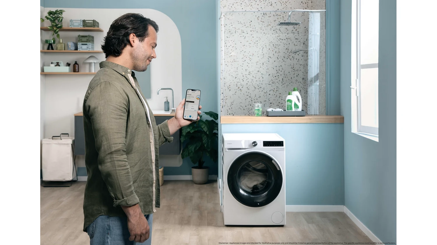 Muž ovl&aacute;daj&iacute;c&iacute; pračku Candy BR 38SBL6-S Slim ProWash 500 pomoc&iacute; mobilu