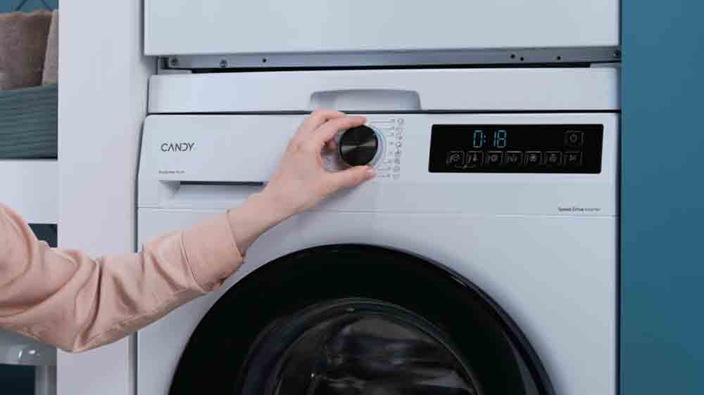 Ženská ruka volí prací cyklus na pračce s předním plněním Candy_05