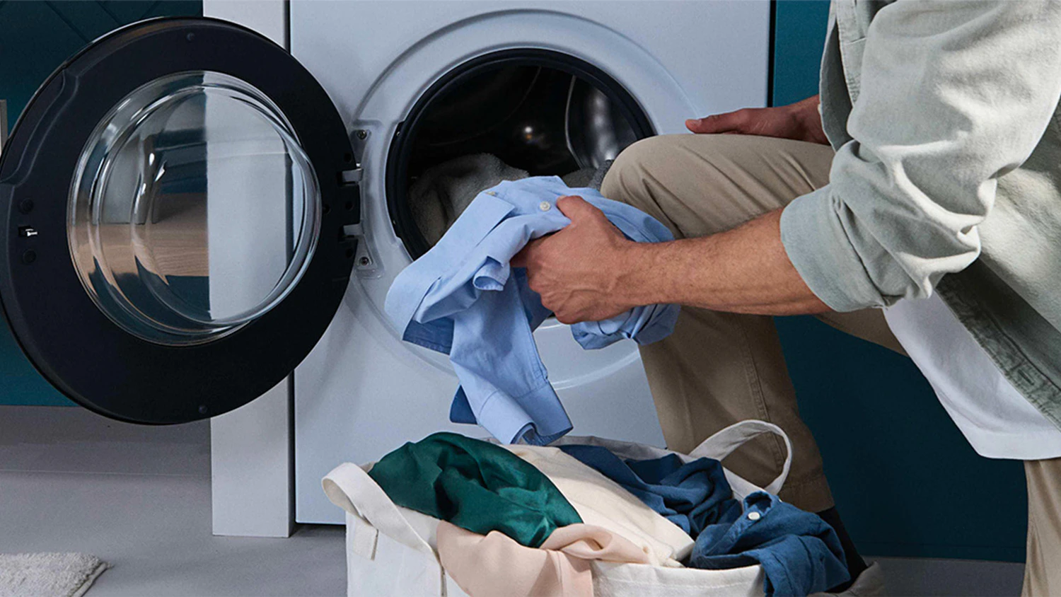 Člověk vytahuj&iacute;c&iacute; pr&aacute;dlo z pračky