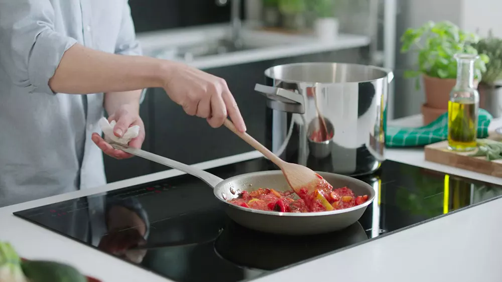 Žena vař&iacute;c&iacute; j&iacute;dlo na desce electrolux LIR60433_03