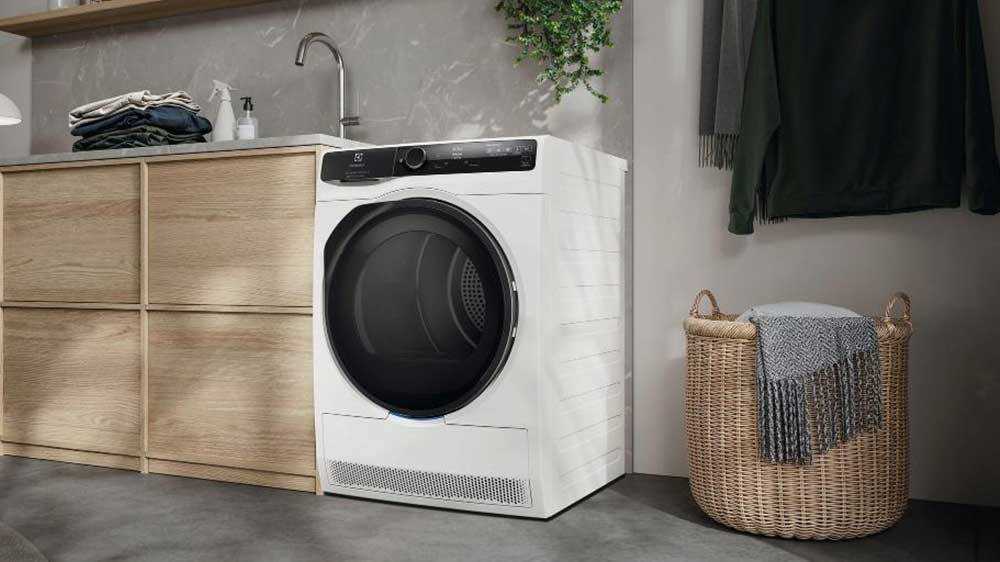 Sušička Electrolux 900 PerfectCare EW9D787KCC umístěna v koupelně vedle koše s prádlem_02
