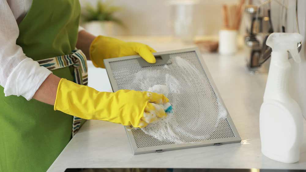 Žena čistící tukový filtr digestoře _03