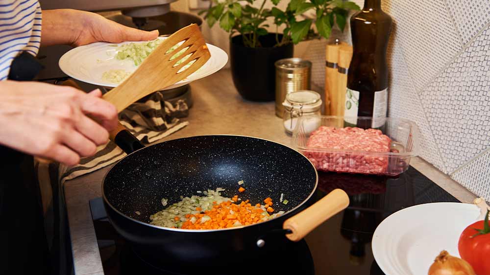 Žena vaří v pánvi na sporáku_02