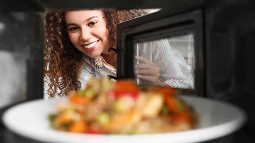 Žena si bere j&iacute;dlo z mikrovlnn&eacute; trouby_02