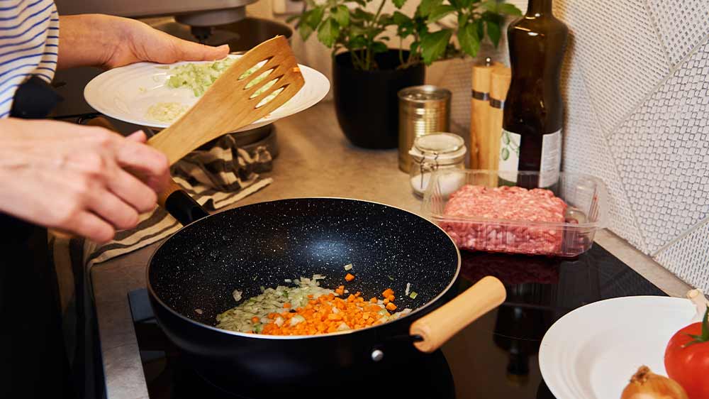 Žena vaří v pánvi na sporáku_02