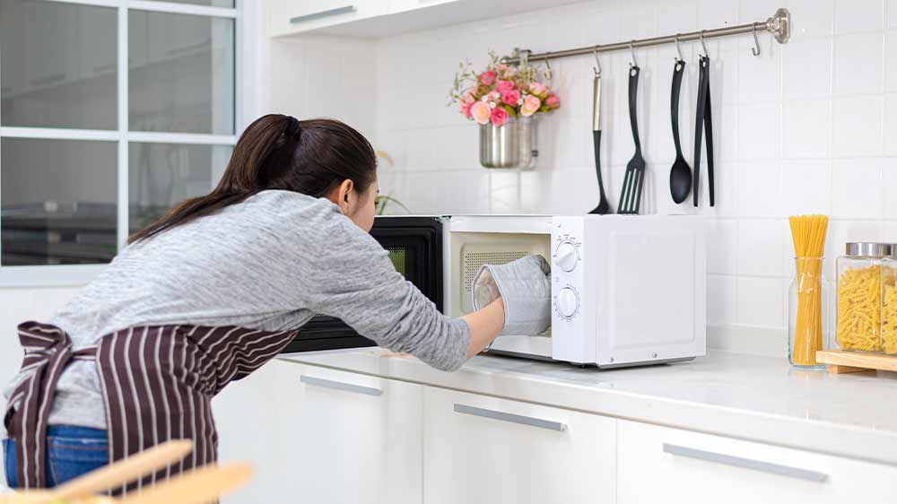 Žena vytahuje jídlo z mikrovlnné trouby_02