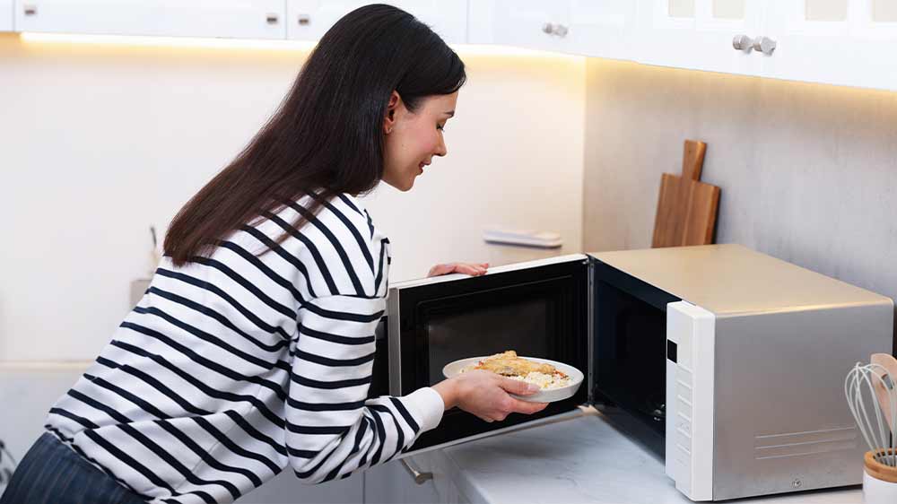 Žena dává jídlo do mikrovlnné trouby_02