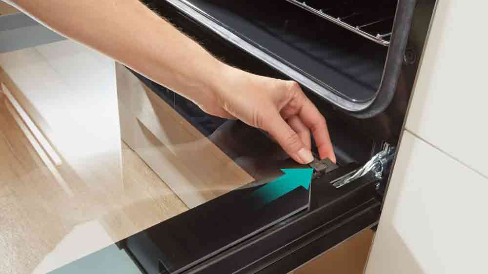 Člověk sundávající sklo dvířek sporáku Gorenje_06