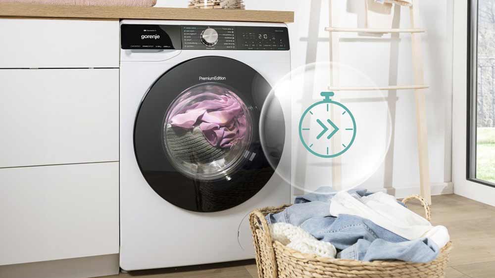 Volně stojící pračka Gorenje W2NS94A1TW/CZ vedle šuplíkové komody pod pracovní deskou s prádlem uvnitř a znázorněním funkce FastWashing_05
