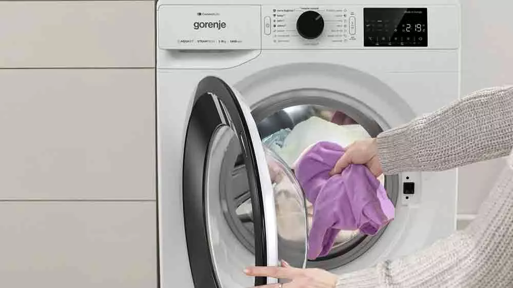 Žena přidává prádlo do pračky Gorenje WPNEI72SA1SWIFI _03