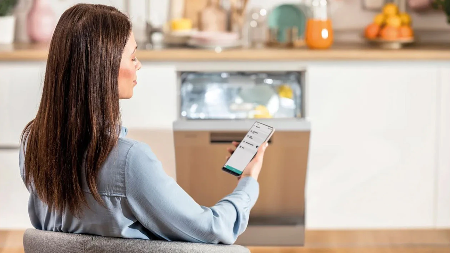 Žena ovl&aacute;d&aacute; svoji myčku přes chytr&yacute; telefon