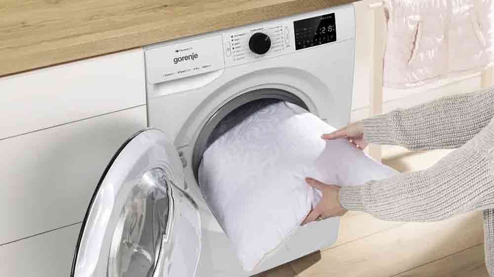 Žena vytahuje polštář z pračky s předním plněním Gorenje WPNEI82A1SWIFI_04