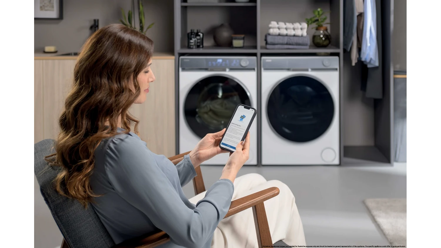 Žena ovldajc pračku Haier HW100-B14387U1 přes smartphone
