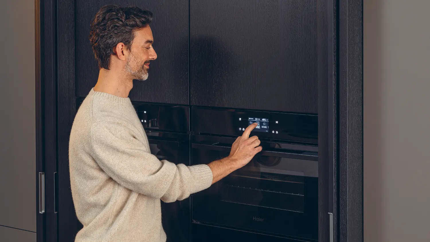 Muž nastavuje troubu Haier H4MWID49C6NQB_02