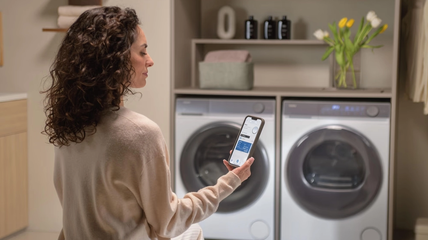 Žena ovládá sušičku prádla Haier X SERIES 7 HD100-C367U1 telefonem